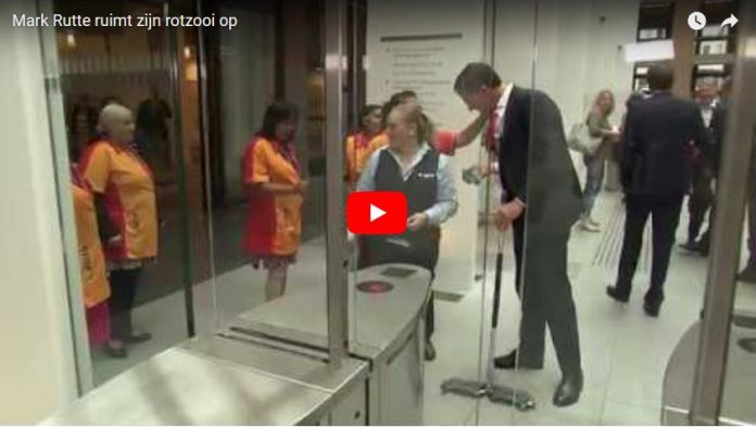 Dutch Prime Minister Mark Rutte mops floor after spilling coffee