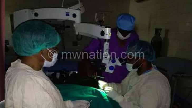 Malawi’s Kamuzu Central Hospital Surgeon uses mobile phone light in theatre operation