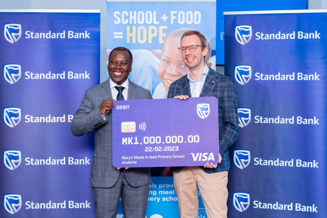 Nyondo (L) presenting a dummy cheque to Bosco (R).jpg